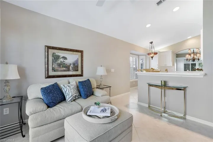Living room featuring light tile patterned flooring and an inviting chandelier