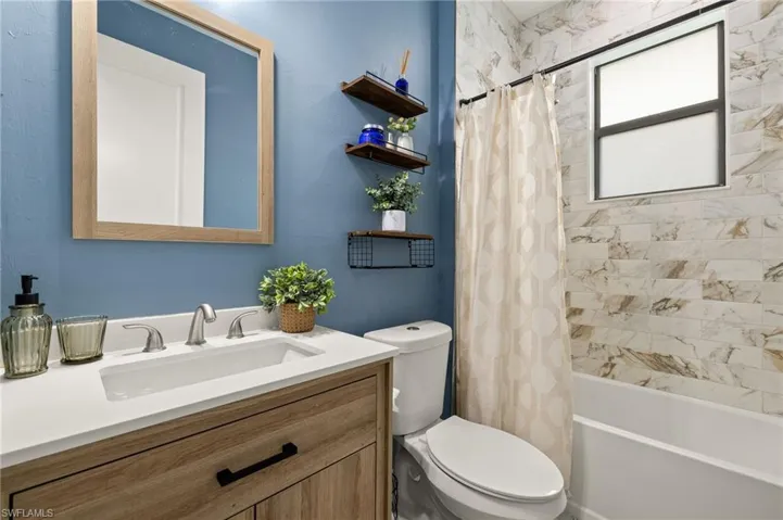 Full bath featuring toilet, shower / bath combo, and vanity