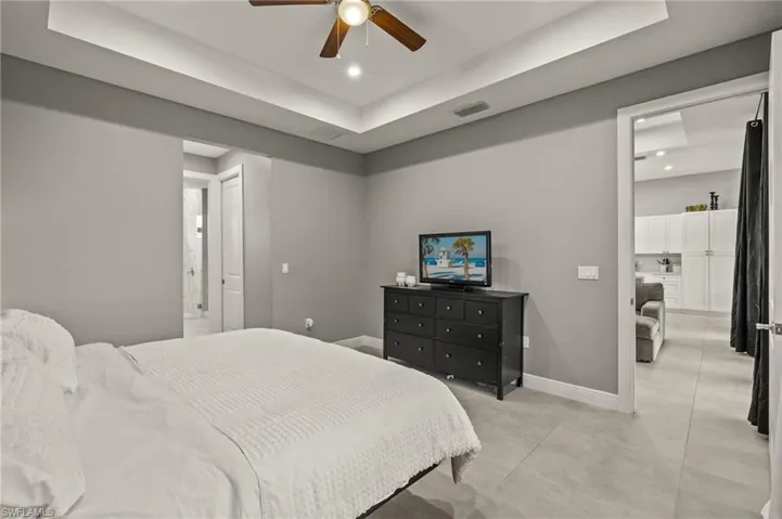 Bedroom featuring a tray ceiling, baseboards, visible vents, and recessed lighting