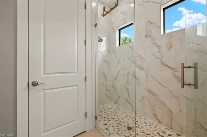 Bathroom featuring a marble finish shower