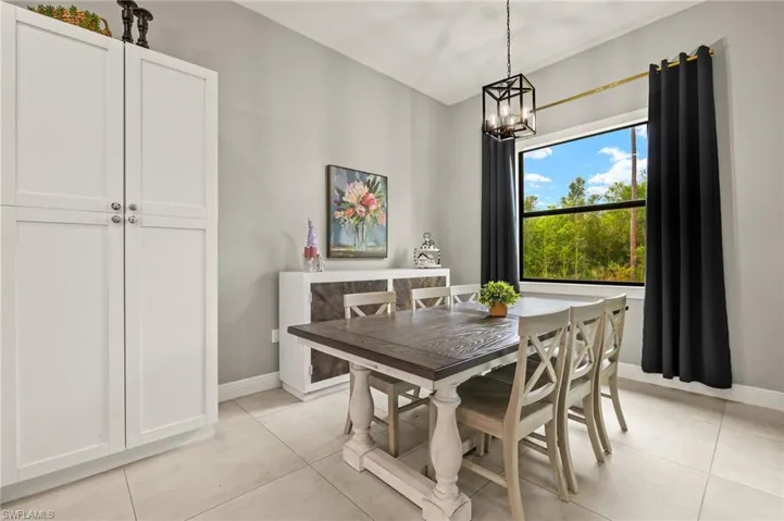 Dining room featuring a chandelier, light tile patterned floors, and baseboards