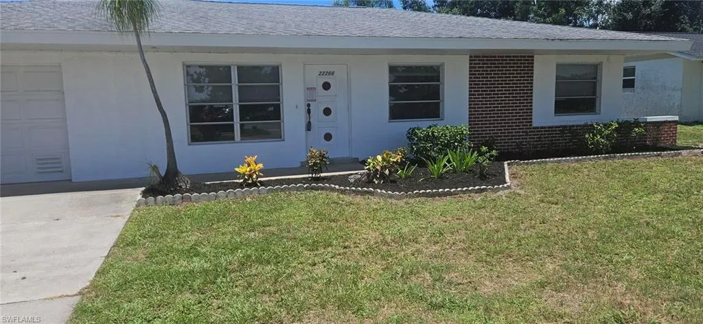 View of front of house with a garage and a front lawn