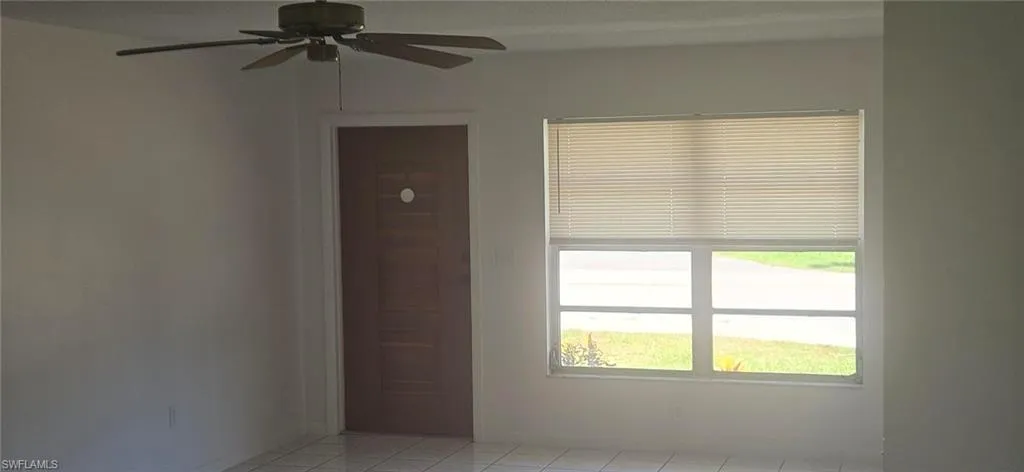 Spare room with ceiling fan and light tile patterned floors