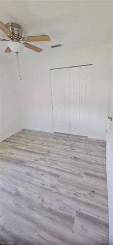 Unfurnished bedroom with light hardwood / wood-style flooring, a closet, and ceiling fan