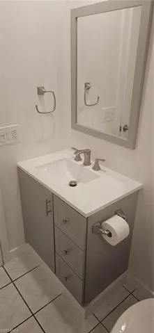 Bathroom featuring tile patterned flooring, toilet, and vanity