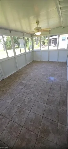 Tiled empty room featuring ceiling fan