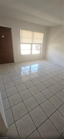 Tiled empty room with a textured ceiling
