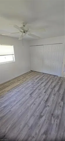 Unfurnished bedroom with a closet, ceiling fan, and hardwood / wood-style floors