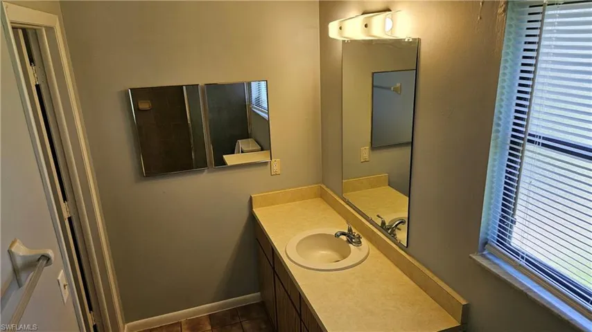 Bathroom with vanity and dark tile patterned floors
