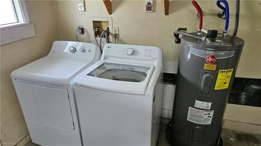 Laundry room with water heater and washing machine and clothes dryer