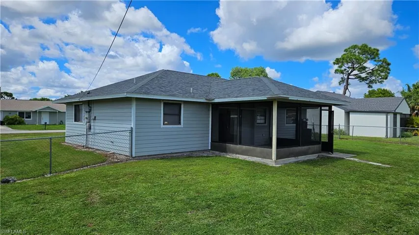 Rear view of property featuring a sunroom and roof with shingles