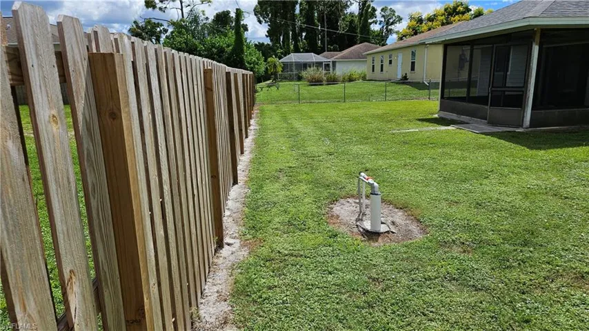 Fenced backyard featuring a sunroom