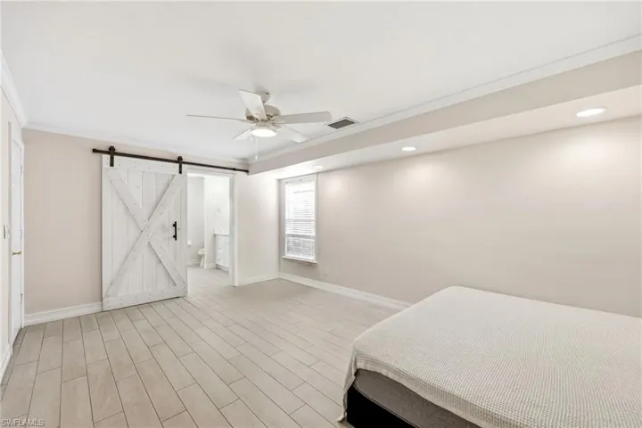 Spacious room featuring light wood-finish flooring, a ceiling fan, and recessed lighting