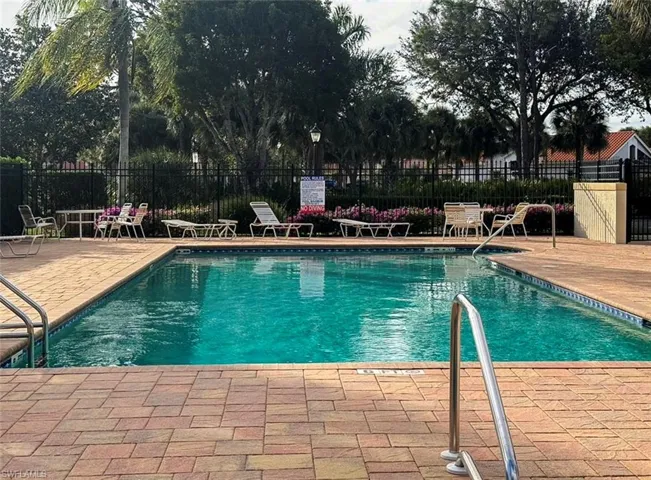 Rectangular swimming pool with a tiled perimeter, surrounded by a paver deck