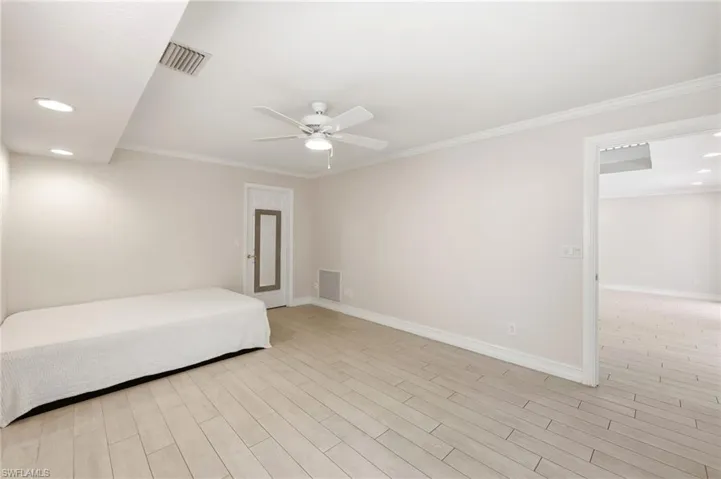 Light-toned wood-finish flooring extending into an adjoining room