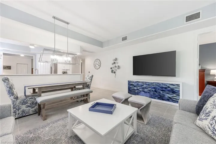 Tiled living room with a notable chandelier