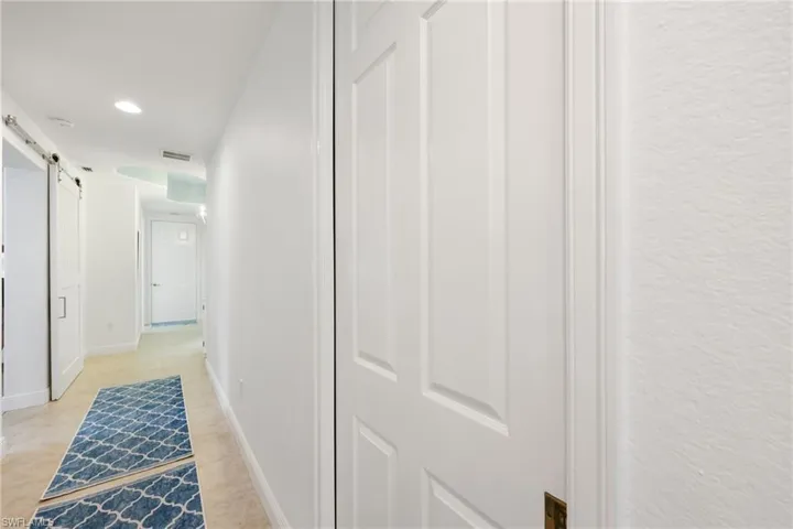 Hallway featuring a barn door and light tile patterned flooring