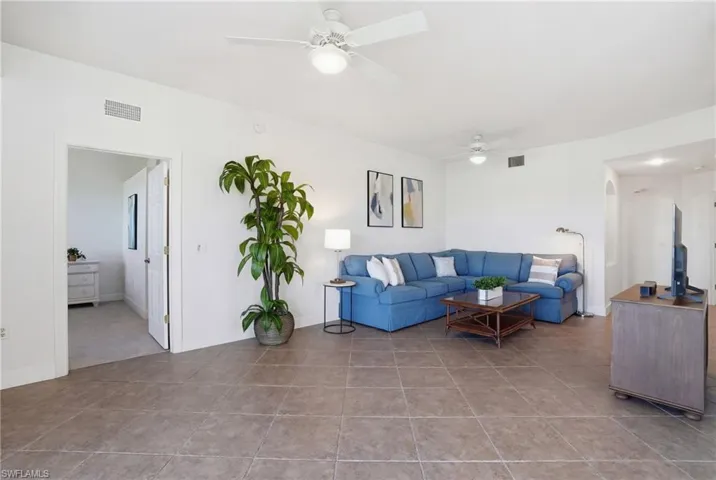 Living area with ceiling fan and light tile patterned floors