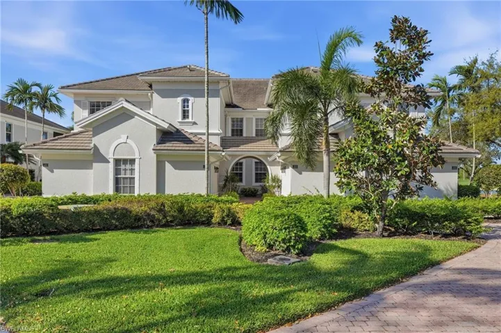 Mediterranean / spanish house with a tile roof, a front yard, and stucco siding