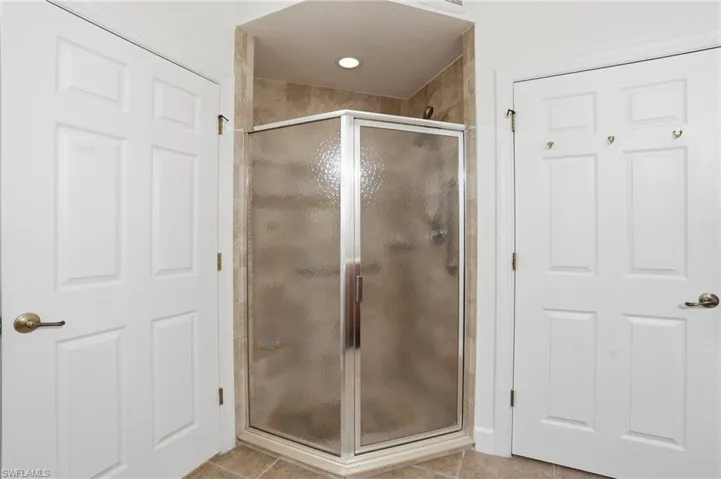 Bathroom featuring a shower stall and light tile patterned floors