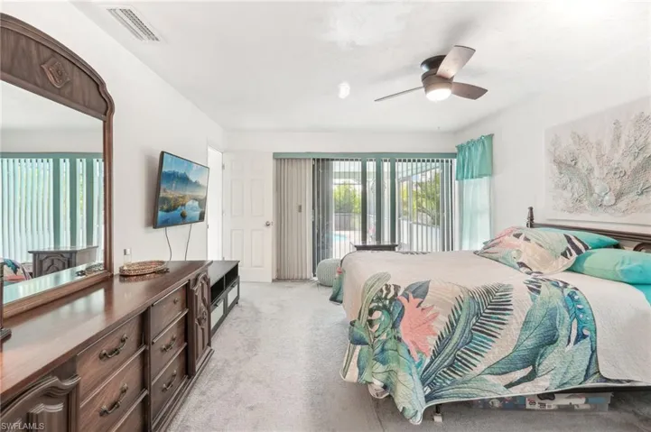 Carpeted bedroom with access to outside and ceiling fan