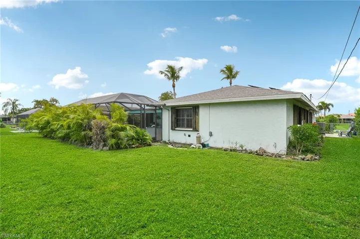 Back of property with a lawn and glass enclosure