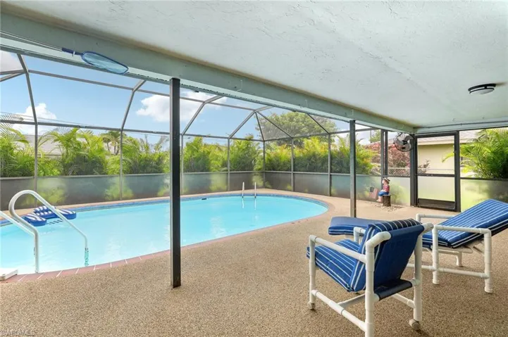 View of swimming pool featuring a patio area and glass enclosure