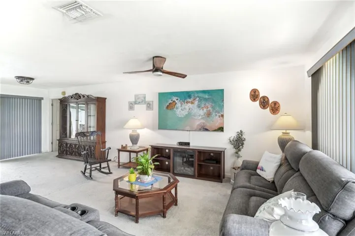 Carpeted living room with ceiling fan