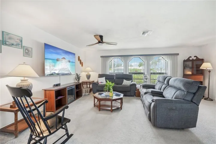 Living room featuring ceiling fan and light carpet