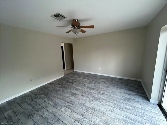 Spare room featuring wood tiled floors and a ceiling fan
