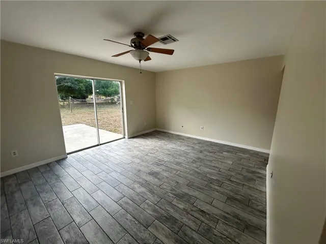 Spare room featuring wood tiled floors and ceiling fan