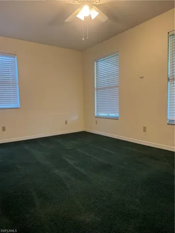 Carpeted empty room with ceiling fan