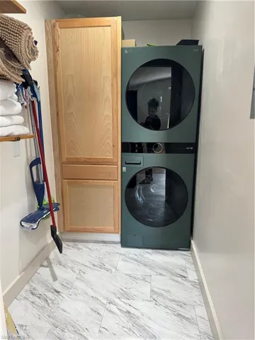Clothes washing area featuring stacked washer and clothes dryer