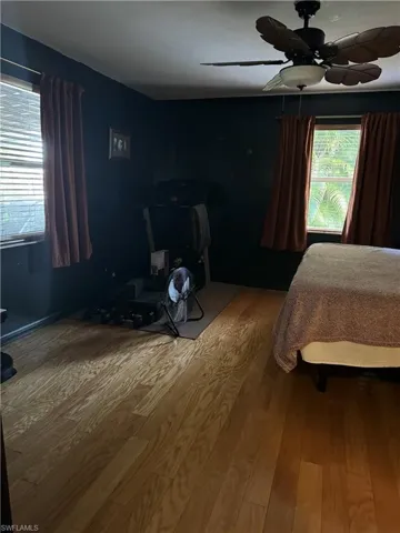 Bedroom with ceiling fan and hardwood / wood-style flooring