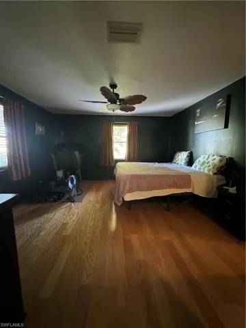 Bedroom with ceiling fan and hardwood / wood-style flooring