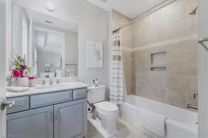 Full bath featuring vanity, shower / bath combination with curtain, and tile patterned floors