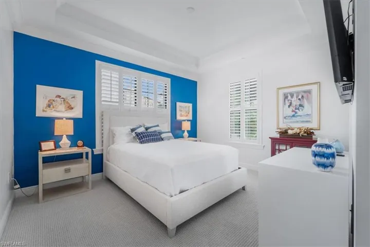 Bedroom featuring a tray ceiling, carpet, and crown molding