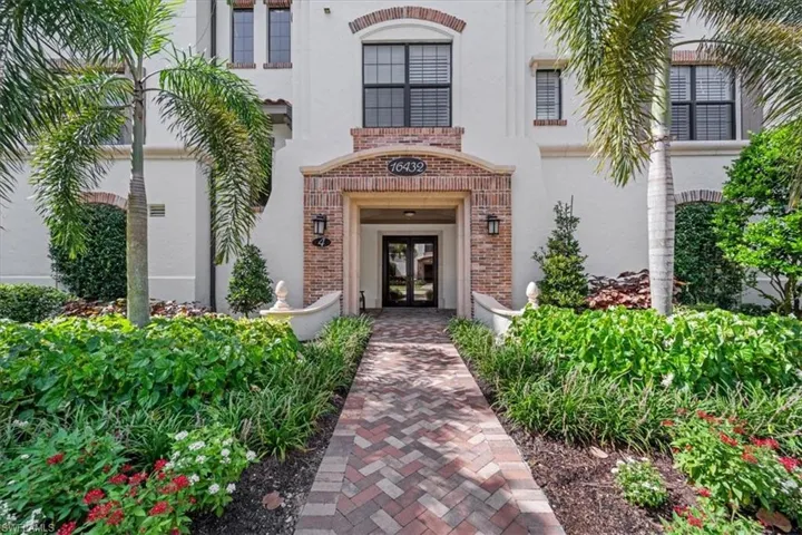 View of exterior entry featuring french doors, brick siding, and stucco siding