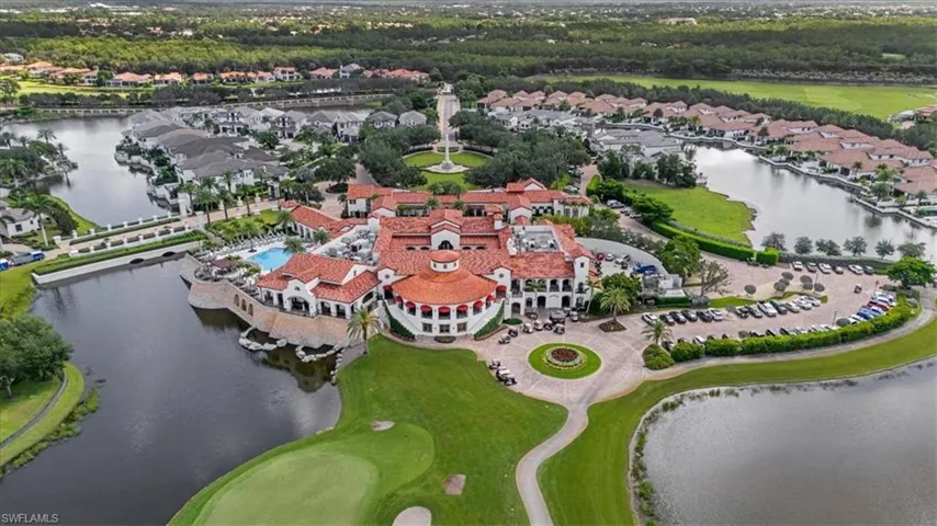 Aerial perspective of suburban area featuring a nearby body of water and a golf course