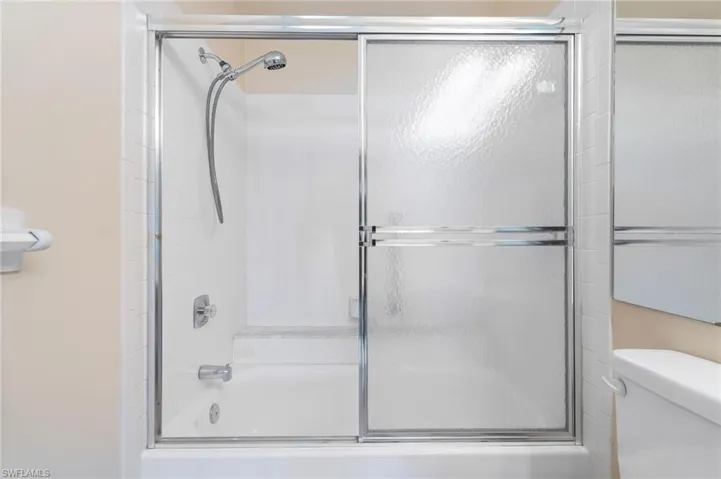 Bathroom featuring toilet and enclosed tub / shower combo