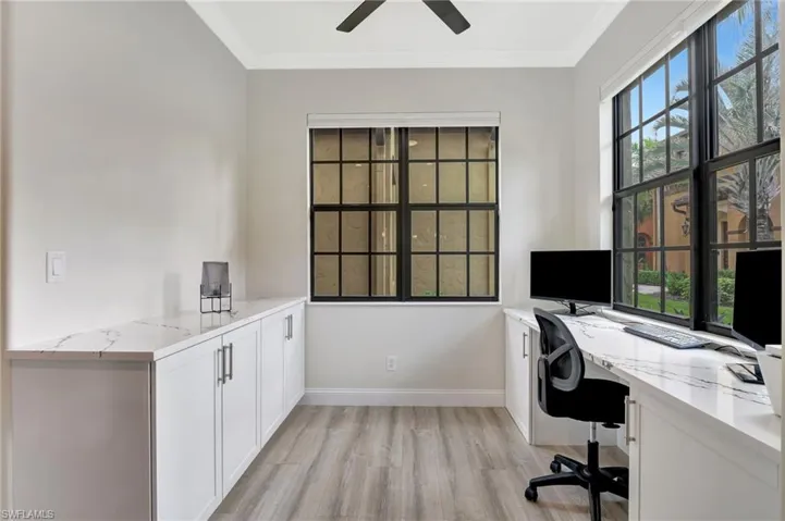 Home office with ceiling fan, ornamental molding, light hardwood / wood-style flooring, and a wealth of natural light