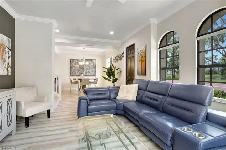 Living room featuring a notable chandelier, light hardwood / wood-style flooring, and crown molding