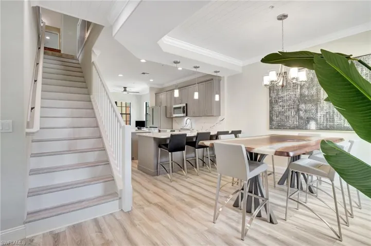 Dining room featuring a chandelier, sink, light wood-type flooring, and ornamental molding