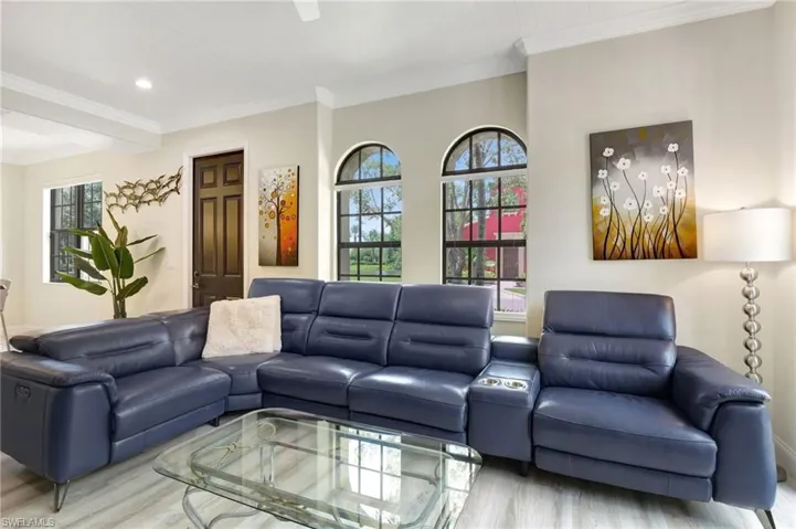 Living room with crown molding, a healthy amount of sunlight, and light hardwood / wood-style flooring