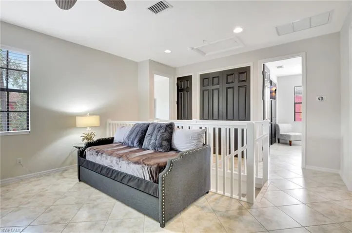 Tiled bedroom featuring ceiling fan