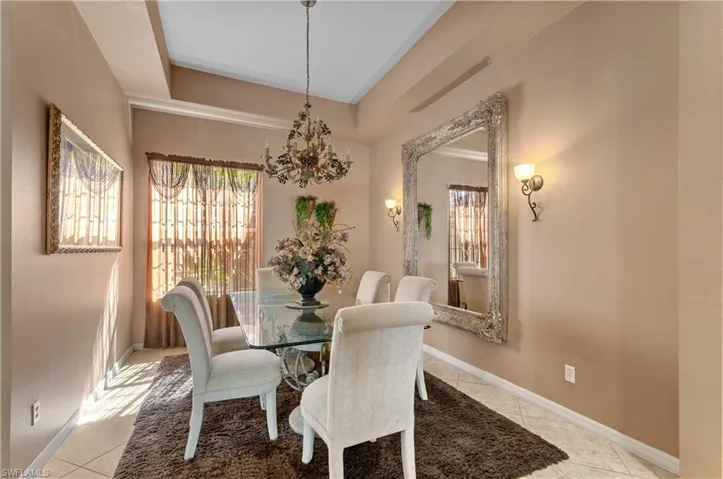 Dining room featuring light tile patterned floors and a notable chandelier