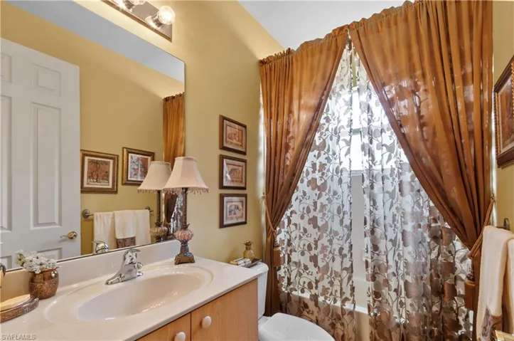 Full bathroom featuring vanity, toilet, vaulted ceiling, and shower / bath combo