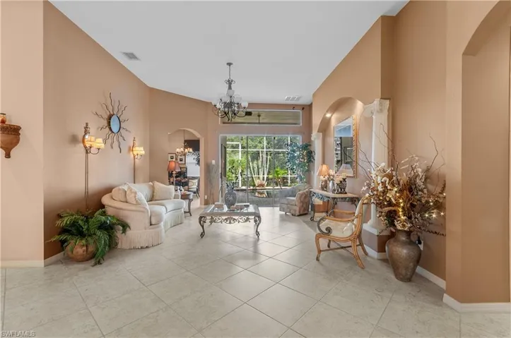 Living room featuring light tile patterned floors and a notable chandelier