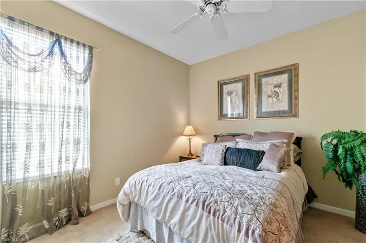 Bedroom with light colored carpet and ceiling fan