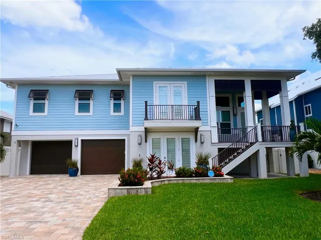 View of front facade with a garage, a porch, and a front yard